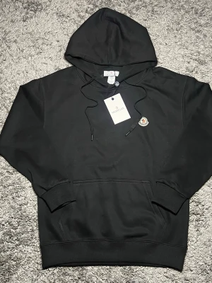 Moncler Hoodie - En svart casual moncler hoodie. Liten mocker logga på bröstet, och luva. Storleken är medium/2