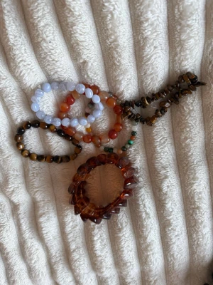 Kristall armband set - Säljer ett helt set armband,  perfekt om du gillar kristaller eller vill bygga upp en snygg samling 💫  Ingår: • 1 st stort bärnstensarmband • 2 st Tigeröga-armband • 1 st Blå spetsagat • 1 st armband med mixade kristaller