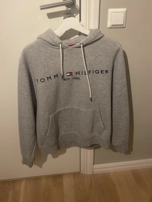 Tommy hilfiger grå hoodie  - Jag säljer en grå Tommy hilfiger tröja för en väldigt bra pris. Säljer den för att den inte passar mig längre.       Pris kan diskuteras!!