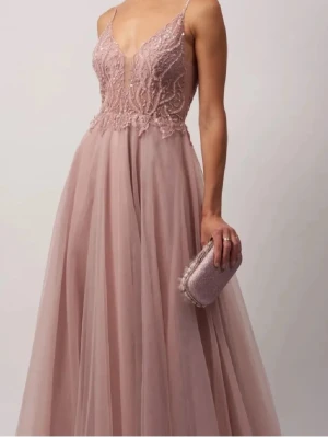 Rosa balklänning - Jag säljer denna jättefina rosa balklänning. Klänningen har spetsdetaljer upptill, en fin rygg och flödande tyll. Klänningens nypris ligger på 3000kr + 300kr frakt, slutsåld i alla storlekar. Den var helt ny när jag köpte den och hade lappar kvar, använd sparsamt en gång och fortfarande i jättebra skick. Tjejen på bilden är 164cm lång och har inga skor på sig. Bilderna är lånade från tidigare säljare 💞 Skriv för mått vid byst och midja. 