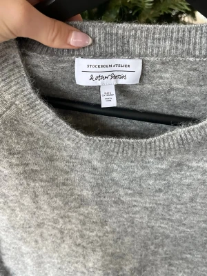 Grå stickad tröja från & Other Stories - Mysig grå mochair stickad tröja från & Other Stories med  trekvartsärm. Jättefin och endast använd en gång, som ny.