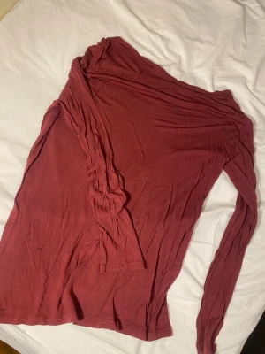 Mörkröd långärmad tröja från Frk - Snygg mörkröd långärmad tröja från Frk i storlek L. Tillverkad i mjuk och tunn lyocell som känns skön mot huden. Tröjan har en enkel och clean design med båtringning och normal passform. 