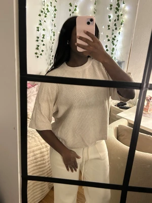 Beige stickad tröja från 157 - Säljer en beige stickad tröja från 157 i storlek M. Tröjan har en loose passform, rund hals och halvkort ärm. Materialet är mjukt och ribbstickat, perfekt för chill dagar. Enkel och clean design som är lätt att matcha med allt.