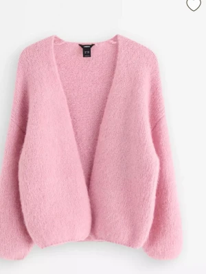 Ljusrosa stickad kofta från Lindex - Mysig ljusrosa stickad kofta med en oversized passform med långa ärmar. Koftan är öppen framtill utan knappar och har en fluffig, mjuk känsla som gör den perfekt för lager på lager under kyliga dagar. Kan skicka bild på hur den ser ut på, om nån undrar om det. Köpt för 399kr. Knappt använd.