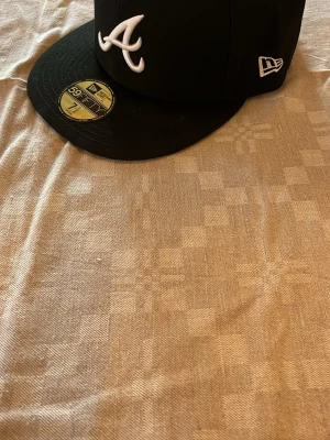 New era atlanta braves keps - En helt sprilans ny new era atlanta braves fitted keps, den är helt oandvänd och har inge promblem. Jag väljer stt sälja den pga att den är för stor