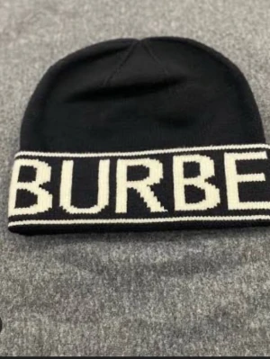 En svart mössa med vit text  - Säljer en helt ny svart mössa med vit text, varm och bekväm, perfekt för det nuvarande vädret 😀