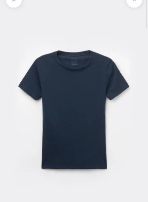 Mörkblå t-shirt - En mörkblå t-shirt med tight passform och rund halsringning. T-shirten är kortärmad och tillverkad i mjuk bomull. Passar dig som vill ha en enkel och fin topp i garderoben.