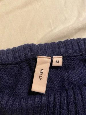 Mörkblå stickade yoga pants från Nelly - Mörkblå stickade yoga pants från Nelly i storlek M. Byxorna har bred ribbad midja och ribbade benslut, vilket ger en chill och mysig vibe. Materialet är stickat och känns mjukt mot huden. 