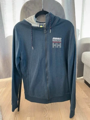 Helly Hansen tröja med dragkedja  - Helly Hansen tröja med dragkedja.  Färg: Blå/marin blå  Storlek: S  Tröjan är i bra skick, inga defekter.