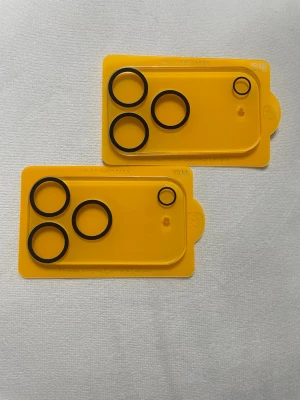 2 st Kameralinsskydd för iPhone 17 Pro Max - Säljer två stycken svarta kameralinsskydd i plast för iPhone 17 Pro Max. Skydden sitter på gula brickor och har tre större ringar samt en mindre ring för kameralinserna. Perfekt för att skydda mobilens kameralinser mot repor och smuts.