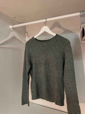 Grön stickad tröja från Vero Moda - Mysig grön stickad tröja från Vero Moda med rund halsringning och långa ärmar. Tröjan har en enkel, klassisk design med ribbade muddar vid ärmslut och nederkant. Perfekt för lager på lager och chill vardagsstil💐