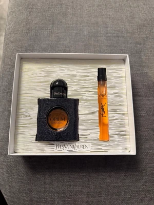Yves Saint Laurent Black Opium set - Säljer ett parfymset från Yves Saint Laurent med Black Opium Eau de Parfum. Setet innehåller en svart glittrig flaska på 30 ml och en smidig 10 ml sprayflaska. Doften är ikonisk och flaskorna har en lyxig design med svart och kopparfärgade detaljer.