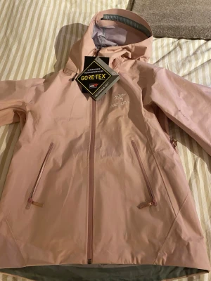 Ljusrosa Arc'teryx vindjacka Gore-Tex - Ljusrosa Arc’teryx jacka, aldrig använd fungerar även för skidåkning med en tunnare dunjacka under. 