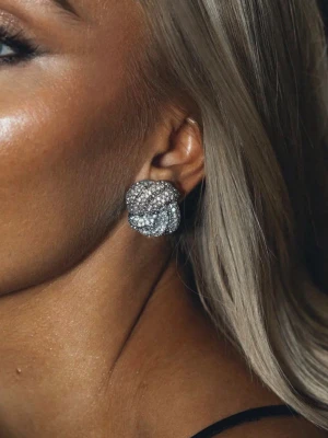 Silverfärgade örhängen från Mockberg - Säljer ett par glittriga silverfärgade örhängen från Mockberg. Nypris är 999kr