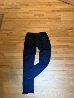  mörkblå jeans - Snygga  jeans med klassisk femficksdesign och raka ben. Jeansen är tillverkade i mjuk bomullsdenim och har en tidlös look som passar till det mesta. Perfekta för dig som gillar en clean och enkel stil.