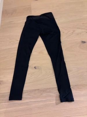 Svarta klassiska leggings - Ett par svarta, enkla leggings med tight passform och hög midja. Perfekta att matcha med oversized tröjor eller hoodies. Mjukt och stretchigt material som gör dem riktigt bekväma. Inga synliga detaljer eller loggor.