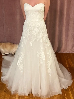 Brudklänning i spets och tyll - En otroligt vacker brudklänning. Tillverkad i spets med en underkjol i tyll och satin. Den har en dragkedja i ryggen och ett brett bh fäste för stöd som går att anpassa efter behov. Storlek 38, Nyskick.   Jag är ca 173cm lång, väger 62kg, normalt en storlek S. Skicka pm för exakta mått, frågor eller om fler bilder önskas! Finns i Kungsängen om man vill prova. 