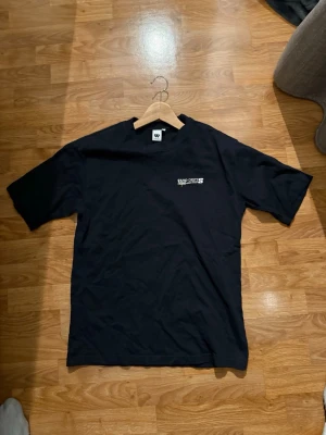 Svart Yard Depts t-shirt - Cool svart t-shirt från Yard Depts med vit text och tryck både fram och bak. På bröstet står det 'Yard Depts' och på ryggen finns ett större tryck med 'Godspeed since 1999'. Klassisk passform och rund hals. Perfekt till streetwear-stilen.