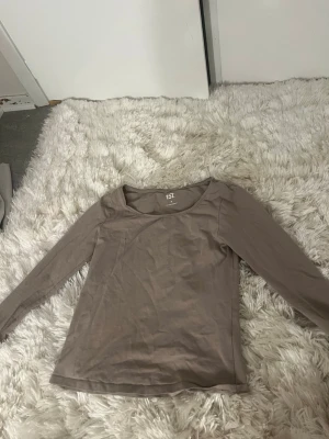 Beige långärmad topp från 157 - En enkel och stilren beige långärmad topp från 157. Tillverkad i mjuk bomull med lite stretch för skön passform. Perfekt basplagg med rund halsringning och normal passform. Material: 95% bomull, 5% elastan.