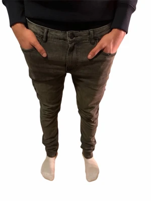 Grå skinny jeans från Perfecto, 32/34 - Säljer ett par grå skinny fit jeans från Perfecto i storlek 32/34. Jeansen har klassisk femficksdesign, bälteshällor och en snygg, smal passform som sitter tight hela vägen ner. Materialet är jeans och färgen är en mörkgrå ton.