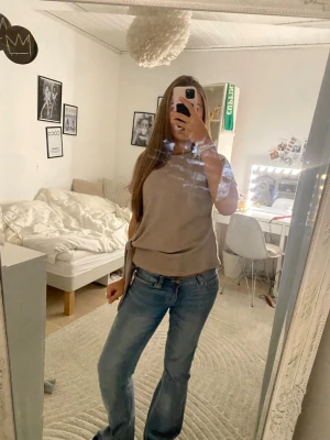 Beige/ brun omlottopp med knyt i sidan - Snygg beige omlottopp med knyt i sidan. Toppen har en lös passform och är ärmlös, perfekt att styla med jeans eller kjol. Mjuk och skön, passar till många olika looks. Den funkar både för vinter och vår. Jag köpte den mindre en ett år sen och har bara andvänd 5-7 gånger ( kontakta om frågor,innan köp och fler bilder ) 