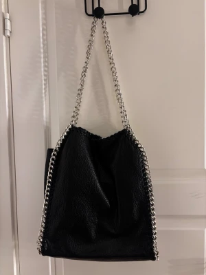 Svart väska med kedjedetaljer - Jätte fin svart väska, ifrån Tiamo! PS! Jag skickar posten om du köper innan kl 17🥰