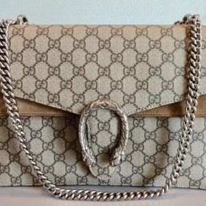 Gucci Dionysus Medium size with the GG Canvas - -Dimension : 30 x 21 x 10 cm  -GG Supreme canvas with suede detailing  -Antiqued silver-tone tiger head closure  -Sliding chain strap that can be used as a shoulder bag  -Flap closure with interior compartments  -The bag is in good condition overall, with a small mark on the back side that does not affect functionality. The interior is clean and well maintained.  -I bought this bag from Vesitaire Collective and the bag is authenticated by the staff there.  -The bag will be delivered with origina