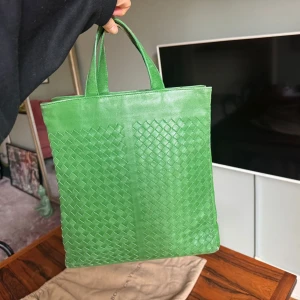 Grön handväska från Bottega Veneta - Snygg grön handväska från Bottega Veneta i äkta skinn med klassiskt flätat mönster. Väskan har två handtag och en stilren, fyrkantig form. Perfekt för dig som vill sticka ut med en färgstark accessoar.