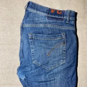 Blå Dondup jeans - Snygga blå skinny jeans men sitter som slim från George med klassisk femficksdesign och diskreta slitningar. Jeansen har normalhög midja och smal passform hela vägen ner. Tillverkade i mjukt denimtyg med stretch för extra komfort. Perfekta för en trendig och avslappnad look. W32 L34 sitter som slimfit, Dm vid frågor pris kan alltid diskuteras‼️♟️