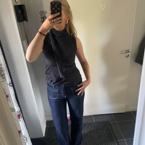 Svart ärmlös polotopp med knyt - Säljer en marinblå ärmlös polotopp som är jättesnygg och skön att ha på sig, aldrig använt❣️❣️