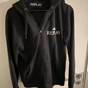 Svart hoodie med dragkedja från Replay - Svart hoodie från Replay med vit logga på bröstet. Storlek M men passar även S. Skick 10/10. Pris kan diskuteras!