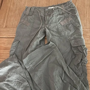 Grå cargobyxor från Diesel - Svin coola cargobyxor från diesel. Vintage stil men köpa nya, använda typ en gång, därmed den lilla slitningen längst ner som syns på sista bilden. 90 cm i innerbenslängd, 36 cm midja rakt över. Perfekt bootcut och sitter jätte najs. Skriv för fler bilder. 100% bomull
