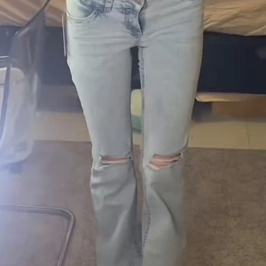 Ljusblå bootcut jeans med slitningar - Säljer ett par trendiga ljusblå Nelly jeans med bootcut passform och slitna detaljer. Har används fåtal gånger. Ny pris 700kr
