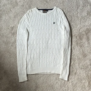 Morris kabelstickad tröja - Vit kabelstickad tröja från Morris med rund halsringning och broderad marinblå logga på bröstet. Tröjan har långa ärmar och ribbade muddar vid ärmslut och nederkant. Perfekt för lager-på-lager och passar helt perfekt nu till hösten och vintern! Storleken är medium men passar L bättre upplever jag. 100% bomull. skriv vid minsta intresse! Mvh DC 🔹