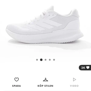 Helvita sneakers från Adidas - Fräscha helvita sneakers från Adidas med klassiska tre ränder på sidan. Ovandelen är i mesh och syntet för en luftig känsla och lätt vikt. Skorna har snörning och en platt sula med Cloudfoam-dämpning för extra komfort. Perfekta för en clean och sportig look. Helt oanvända och kvar i låda, därav bilder från hemsidan. Nypris 700kr.