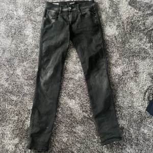 Svarta Replay Anbass slim jeans - Säljer ett par snygga svarta Replay Anbass jeans i slim fit. Perfekta nu till hösten. Nypris 1800kr. Hör av dig vid fundering!