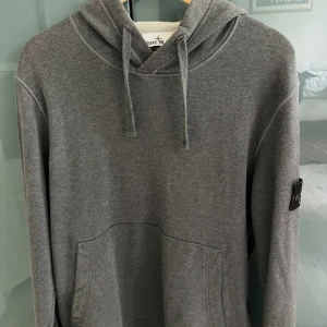 Grå hoodie från Stone Island - Säljer en grå hoodie från Stone Island med klassisk logga på på ärmen. Mycket bra skick storlek medium äkta såklart hör av dig om du vill ha bild på certilogo! Nypris 3500 mitt pris 1899.