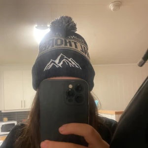 Mörkblå Val Thorens mössa med tofs - Från kindwear uf nypris 300