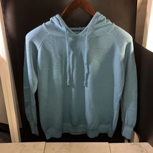 Merinoull tröja - Säljer en ljusblå hoodie med långa ärmar och justerbar huva. Perfekt för en avslappnad stil. Den är helt oanvänd vilket gör detta till ett mycket fint pris. OBS! Tröjan sitter hyfsat tajt i ärmarna samt sitter den mer som en S än M. Hör av er vid minsta fundering🙌
