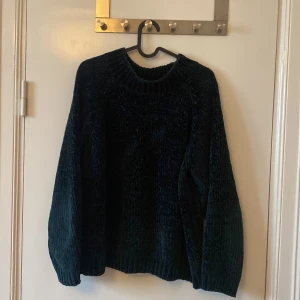 Mörkblå sammetströja Gina Tricot M - Mysig mörkblå/grön stickad tröja från Gina Tricot i ”sammetskänsla”. Tröjan har en chunky ribbad krage och långa ärmar med avslappnad passform.