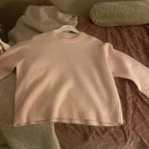 Ljusrosa stickad tröja med rund hals från Gina tricot - Supermjuk och fluffig ljusrosa stickad tröja med rund halsringning och ribbade muddar. Perfekt för lager-på-lager och ger en chill vibe till din outfit. Långärmad och lite oversized fit för extra mysfaktor.