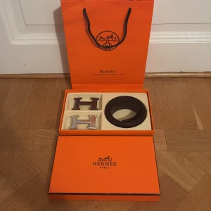 H-spänne bälte svart - Är i fint skick nästan nytt. Allt levereras i original boxen och påse. Perfekt accessoar för att lyfta din outfit. Bältet är 110 cm långt. 