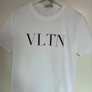 Valentino T-shirt - Stilren och tidlös Valentino T-shirt i vitt – perfekt för både vardag och fest. Exklusiv design med högkvalitativ bomull som ger en skön passform och elegant look. Minimalistisk men lyxig – ett måste i garderoben för dig som vill kombinera enkelhet med modeikonisk känsla.