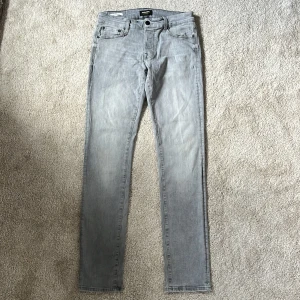 Jack & Jones jeans ljusgrå - Snygga ljusgrå jeans från Jack & Jones med klassisk femficksdesign och raka ben. Jeansen har en ljusgrå tvätt och subtila slitningar för en modern look. Tillverkade i mjukt bomullsmaterial med en bekväm passform och normal midja. Modellen heter slim/Glenn och är i storlek 30/34. Skriv vid minsta intresse 🤗