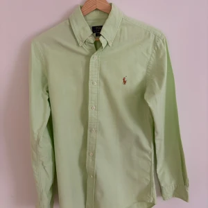 Ljusgrön skjorta Polo Ralph Lauren - Ljusgrön skjorta från Polo Ralph Lauren i slim fit storlek S. Skick så gott som ny! Klassisk oxfordmodell med knappar hela vägen, broderad logga på bröstet och lång ärm. Nypris ca 1700 kr.