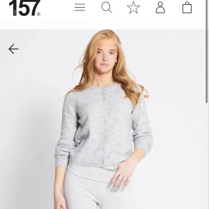 Ljusgrå kofta från 157, storlek M - Mysig ljusgrå kofta från 157 i storlek M. Koftan har rund halsringning, knäppning framtill med små knappar och långa ärmar. Perfekt för lager-på-lager och enkel att matcha med andra plagg.