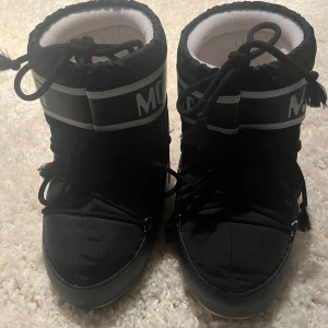 Svarta Moon Boots med snörning - Säljer mina moon boots i storlek 36-38 som bara kommit till användning en gång!