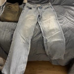 Ljusblå raka jeans från Levi's - Säljer ett par ljusblå jeans från Gina med klassisk femficksdesign och raka ben. Jeansen har normal midja och är tillverkade i robust denim. Perfekta för en avslappnad och trendig look.