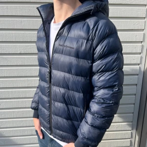 Varm Peak Performance dunjacka  - Snygg varm mörkblå dunjacka från Peak Performance med huva, perfekt till kallare tider. Skick 9/10 utan defekter som ny. Nypris ligger på 2799kr men säljs nu för 899kr. Hör gärna av er vid minsta lilla fundering.