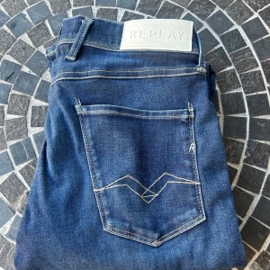 Blå jeans från Replay - Säljer ett par snygga blå jeans från Replay, modell Anbass. Jeansen är i bra skick har inga defekter, storlek 30/32. Skriv om ni har fler frågor!😄